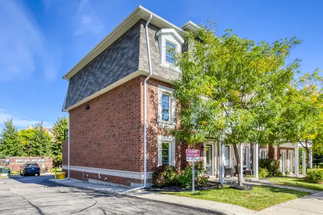 Side view of the brick end-unit townhome from the driveway