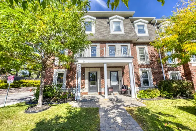 Front of 2375 Truscott Drive, Unit 1, a three-storey brick end-unit townhome with a covered porch